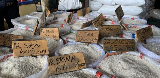 Isu Beras Oplosan Bikin Omzet di Pasar Cipinang Terjun Bebas Karung beras berbagai merek di gudang distribusi sebagai ilustrasi harga beras mahal.