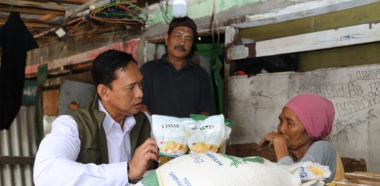 Dirut Bulog Sidak Penyaluran Bantuan Pangan di Marunda: Cukup Bawa KTP Rizal mengenakan rompi saat membagikan bantuan beras.